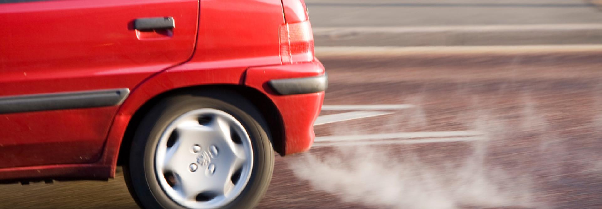 Fumée sortant d'un pot d'échappement d'un véhicule rouge 