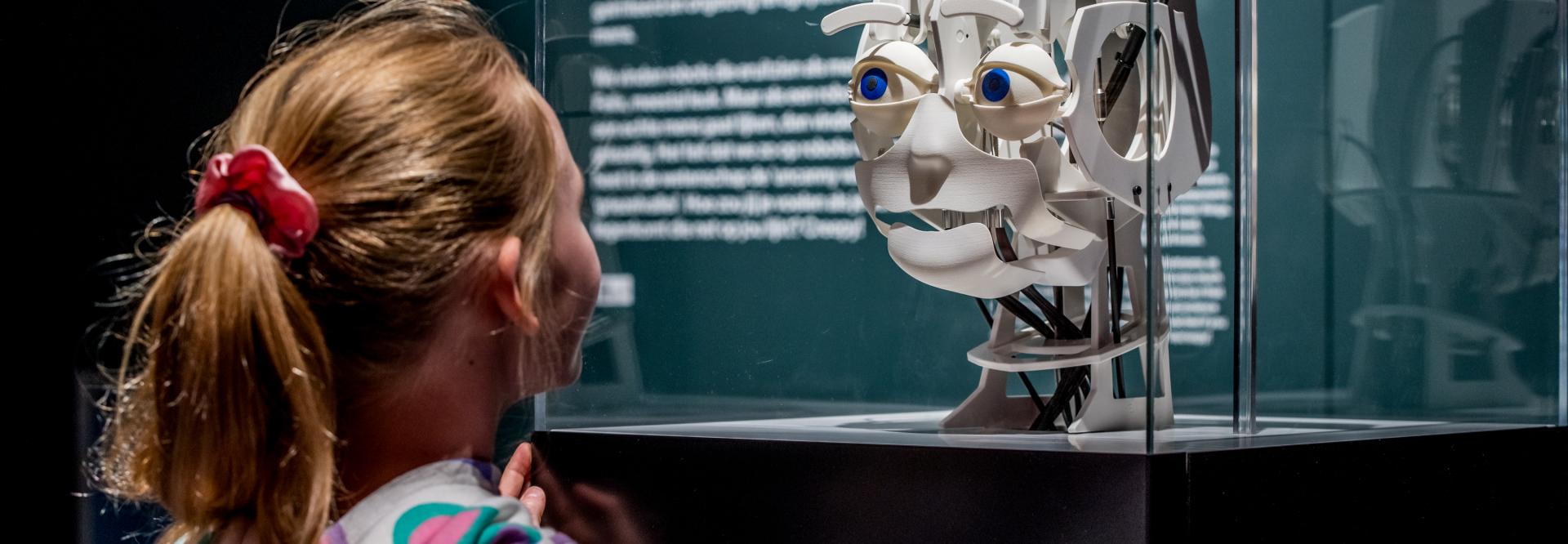 Meisje die kijkt naar een robothoofd