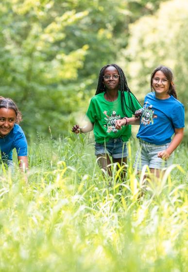 4 enfants souriants marchent dans les hautes herbes - WWF-Rangerclub
